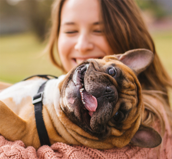 Jeune femme avec un chien dans les bras