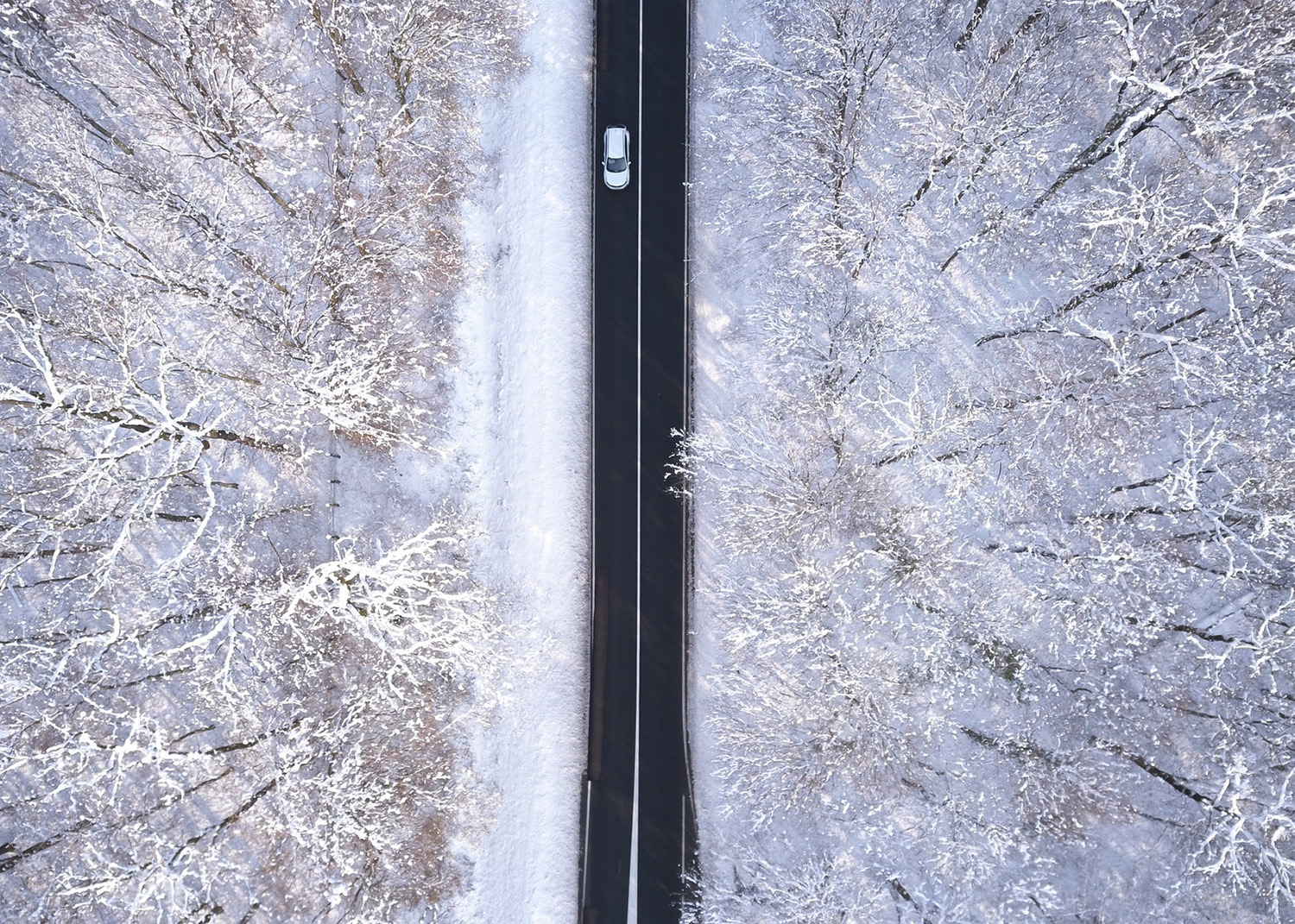 Voiture qui roule sur une route l'hiver
