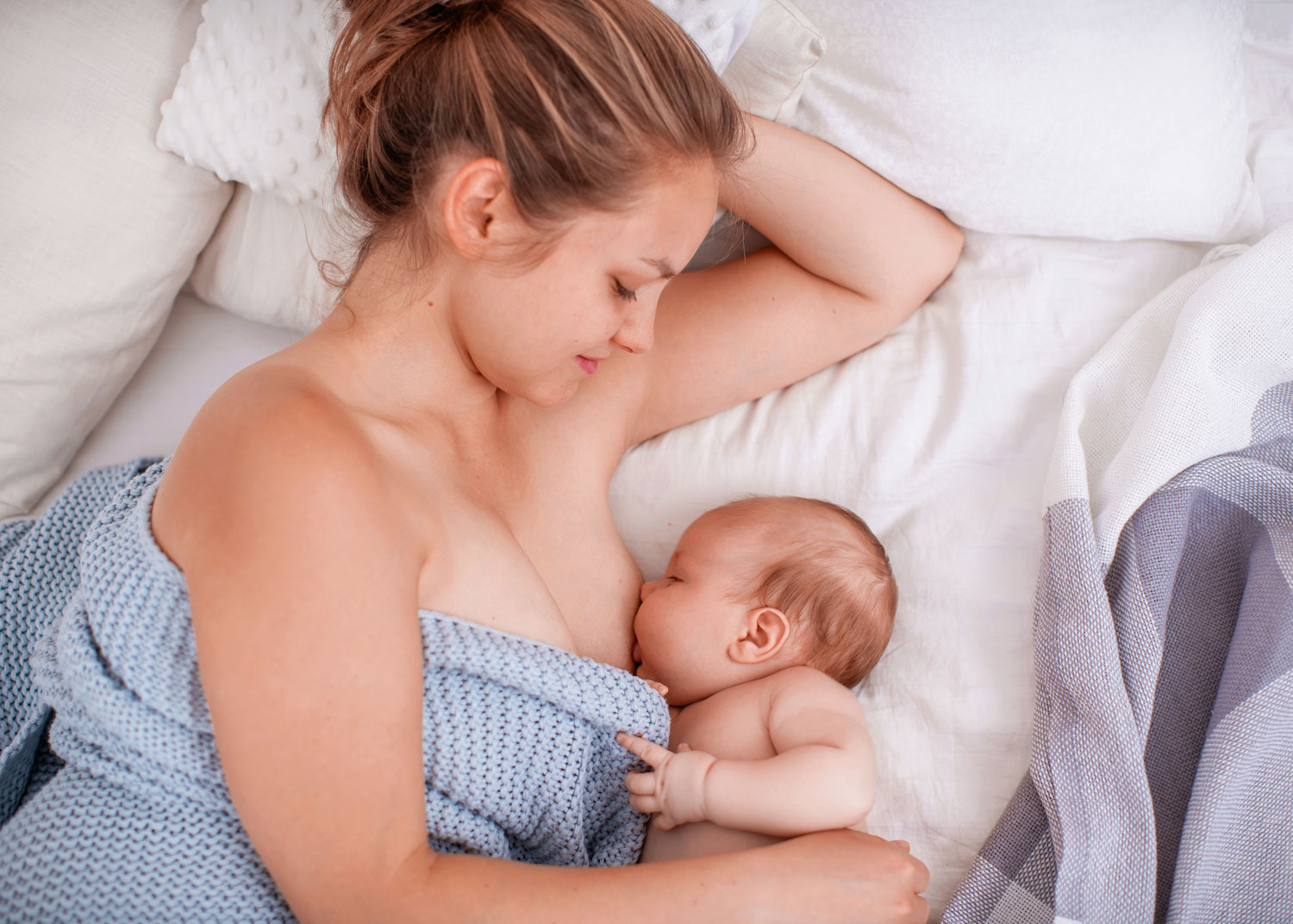 femme allaite son nouveau-né étendue pour diminuer l'engorgement