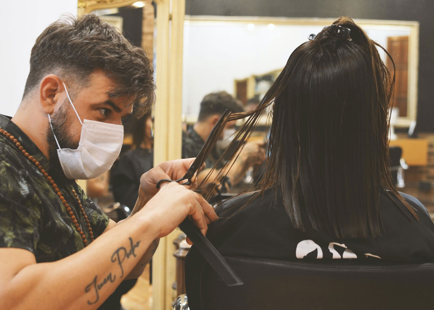 femme se fait couper les cheveux par un coiffeur