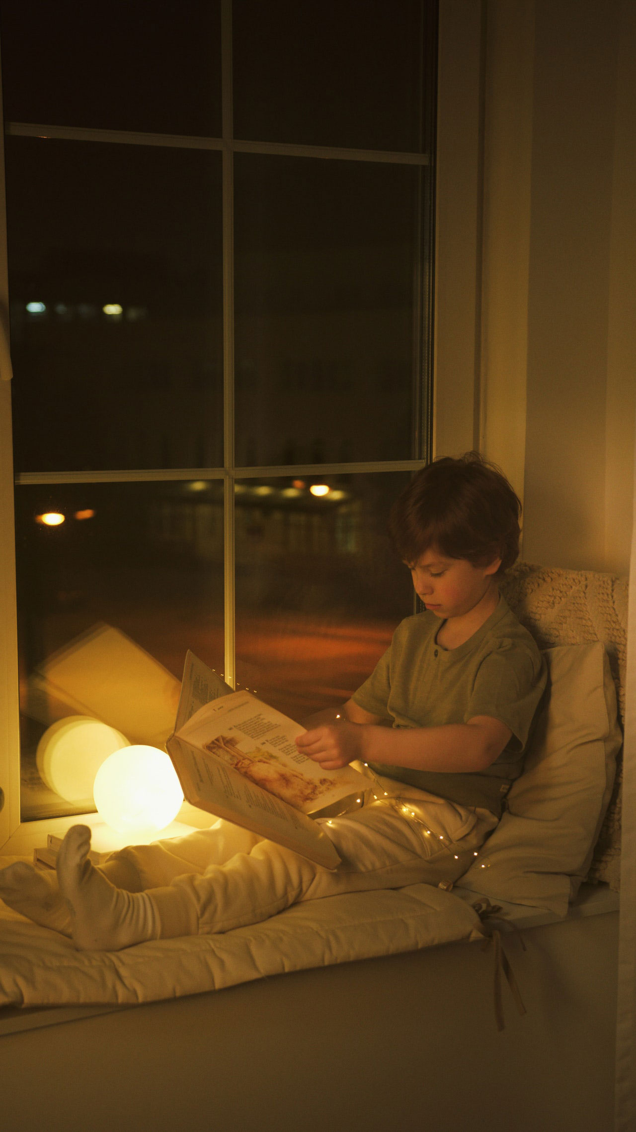 jeune garçon regarde livre pour relaxer durant la semaine de relâche