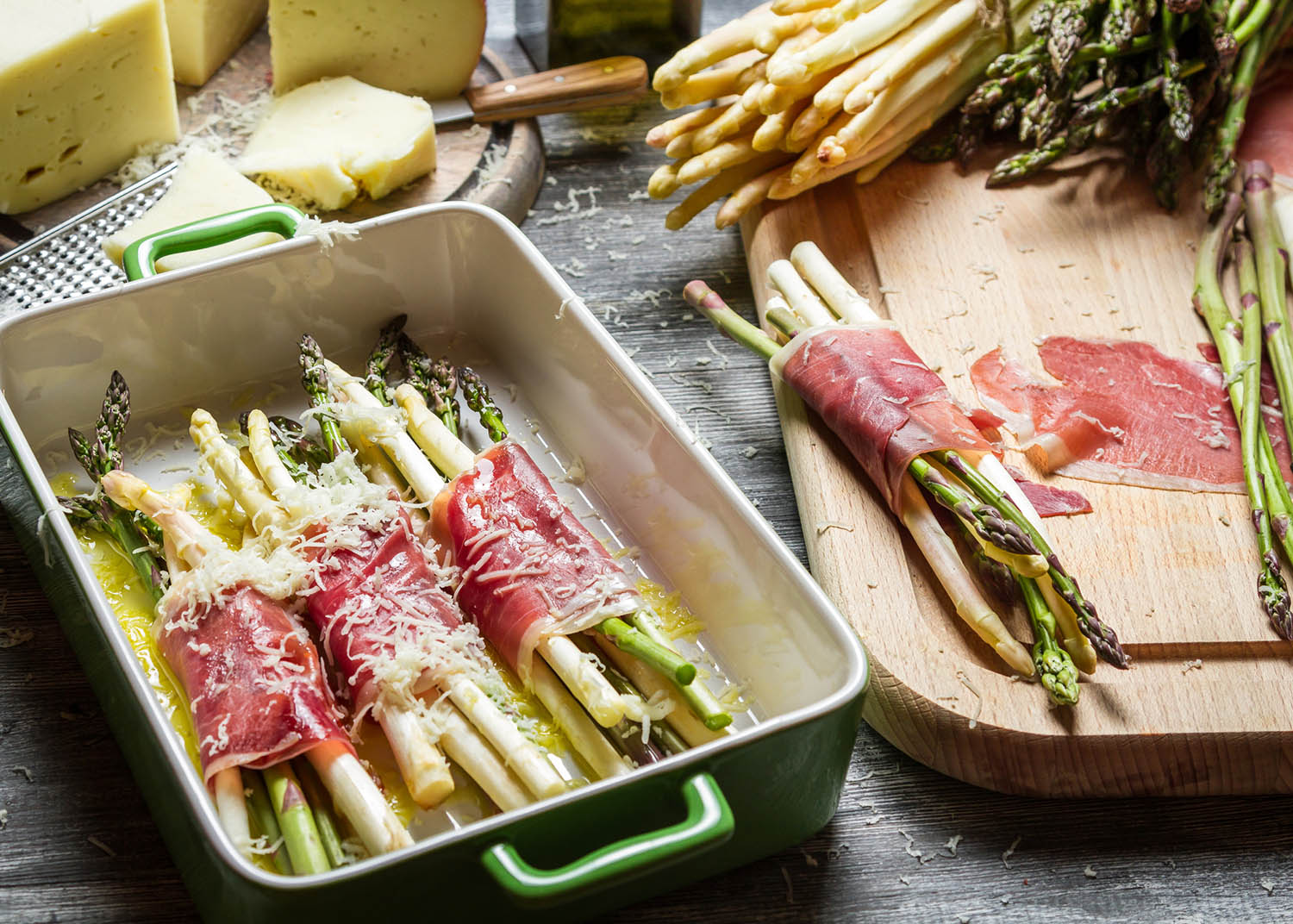 Preparation of asparagus wrapped in Parma ham with cheese.