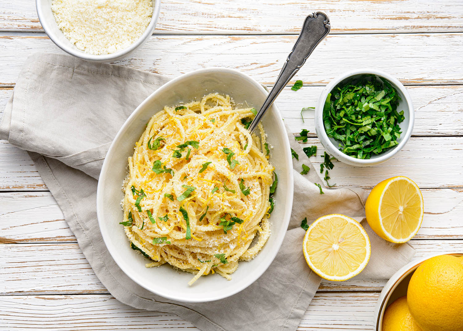 Pasta al Limone, delicious Italian meal, spaghetti with Parmesan, butter and lemon sauce, topped with fresh grated zest and cheese on rustic wooden background