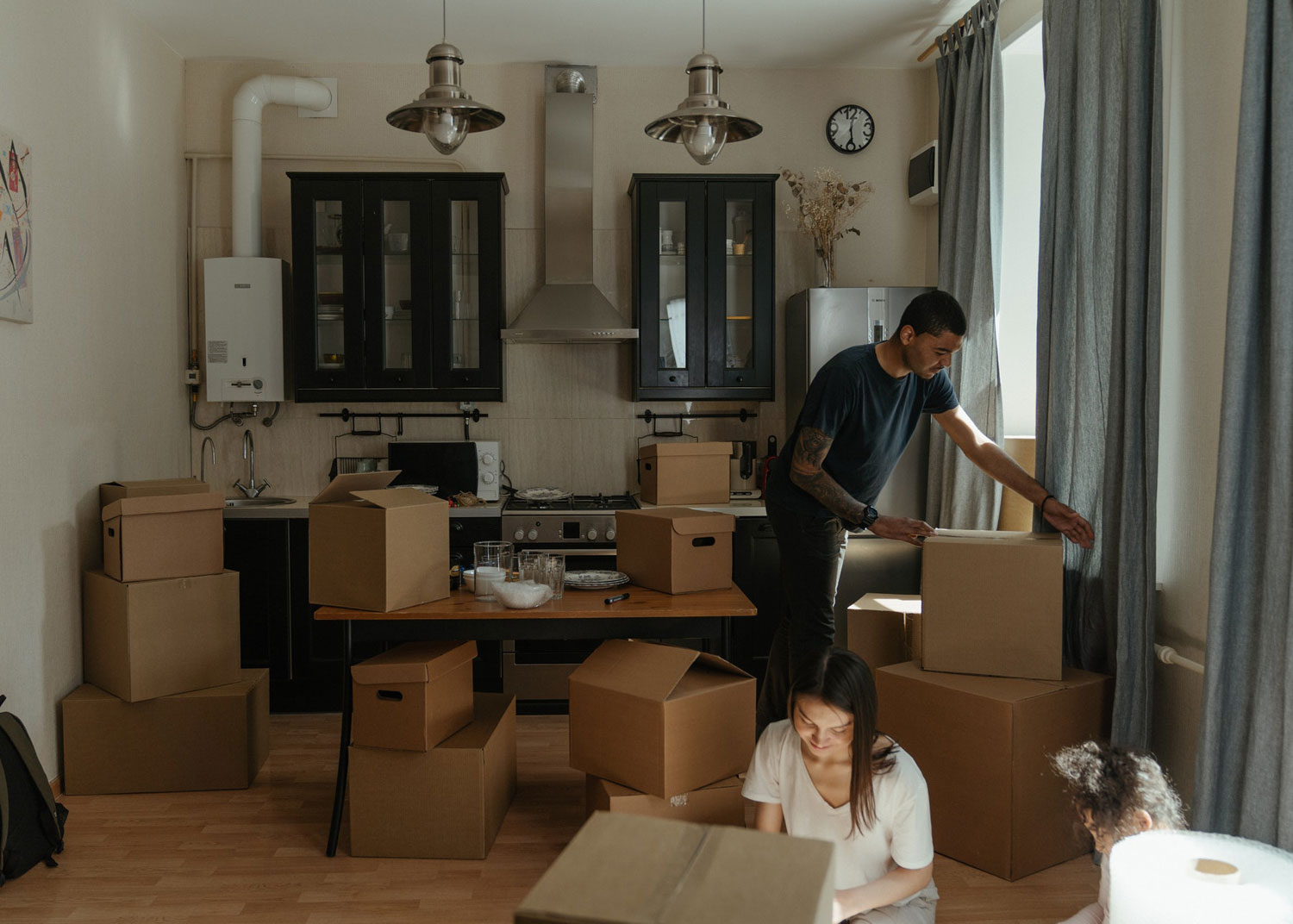homme et femme avec enfant font des boites pour préparer un déménagement