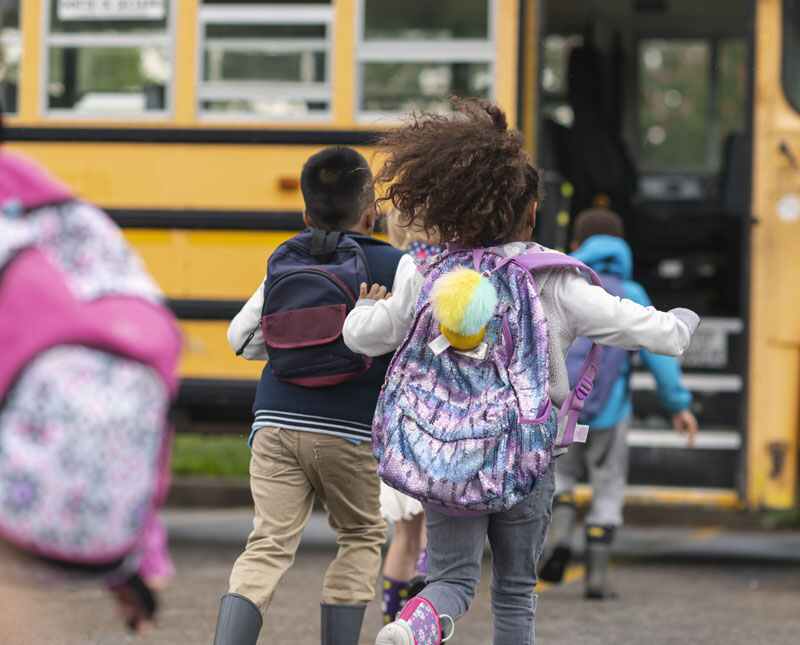 Enfant qui court vers autobus scolaire