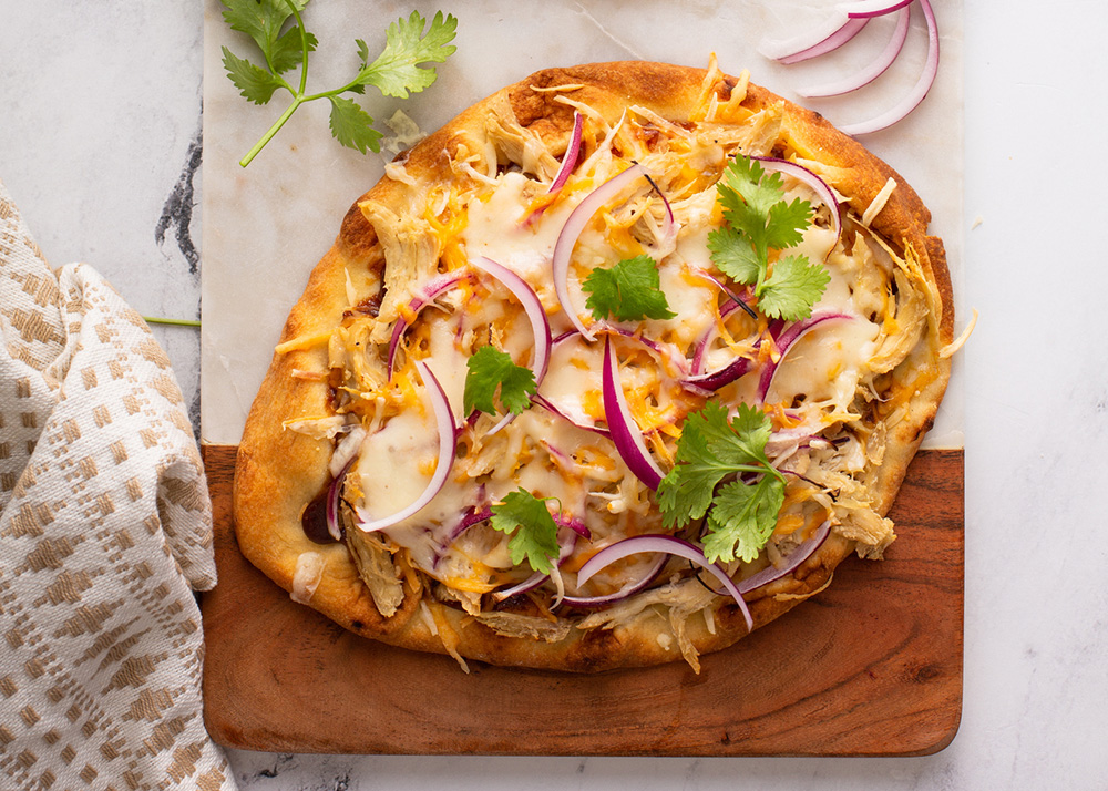 Barbeque chicken flatbread with BBQ sauce, cheese and red onion