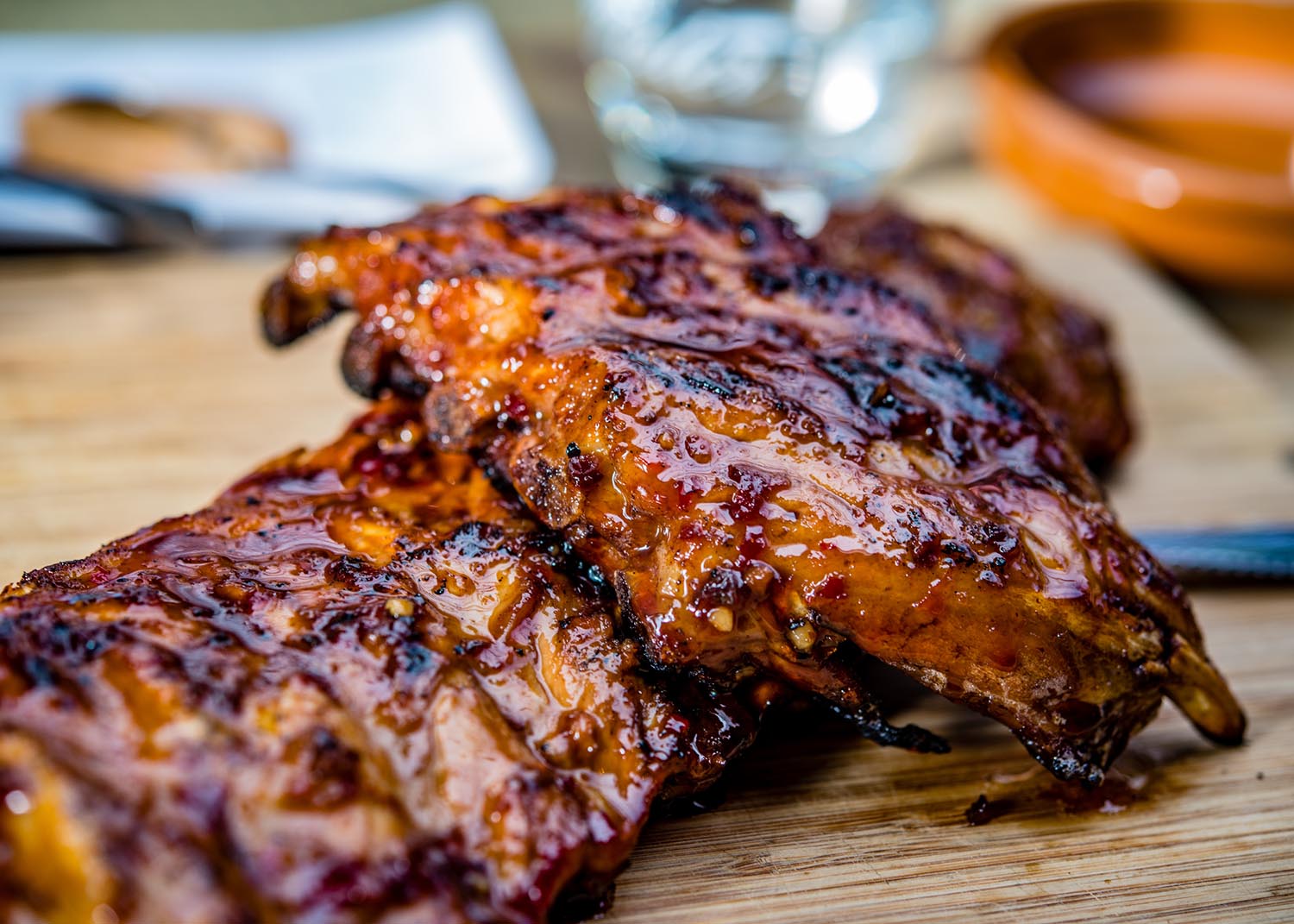 close up of golden colored juicy roasted spare ribs on a wooden plate