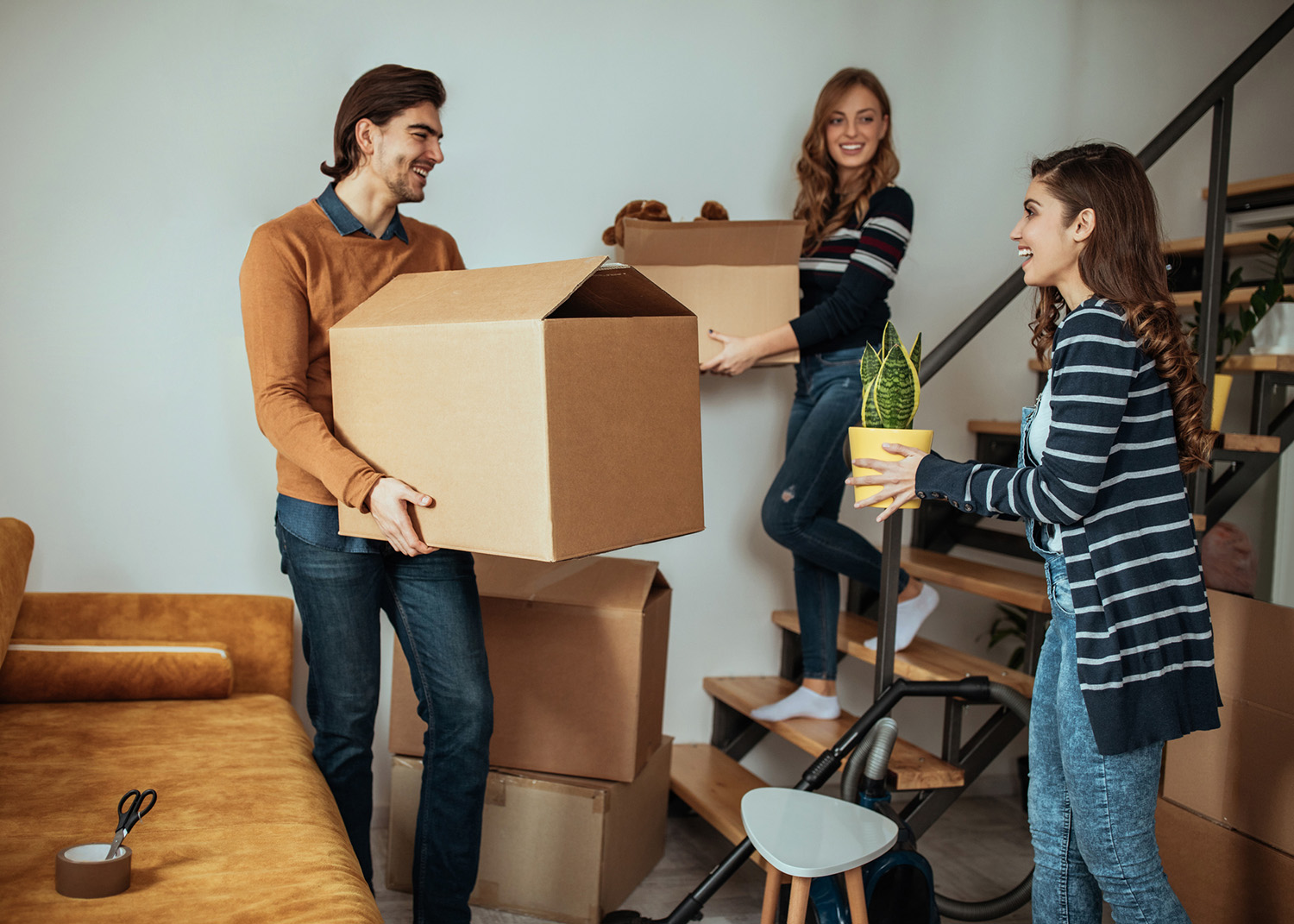 Group of friends packing up boxes for moving into new apartment