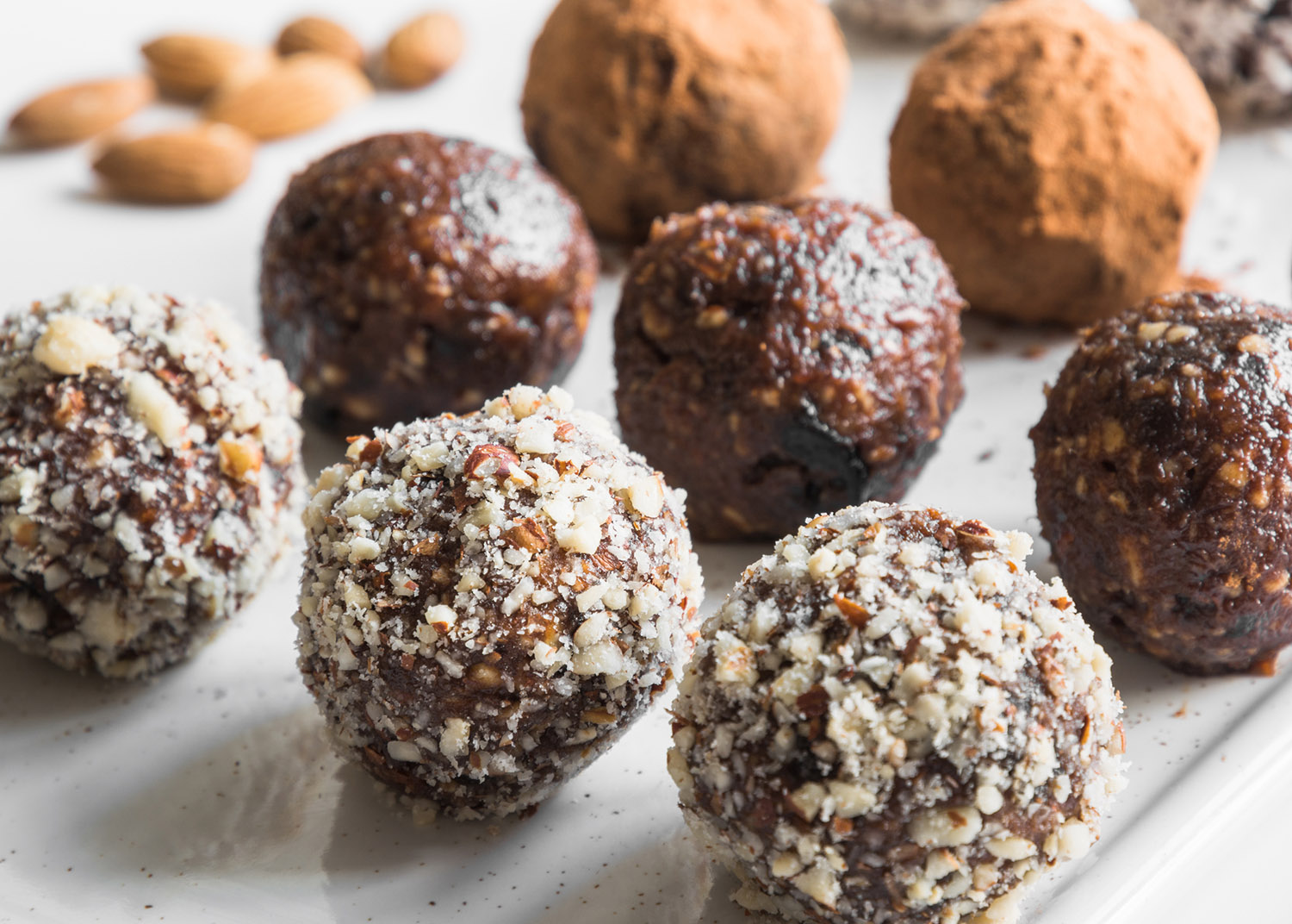 Homemade energy bites, vegan chocolate truffle with nuts, cacao and coconut flakes. Concept healthy food. Close up.
