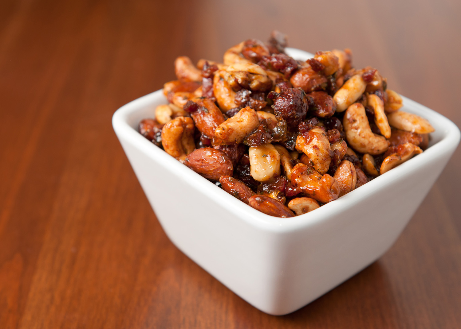 A bowl full of homemade bacon-maple spiced nuts.