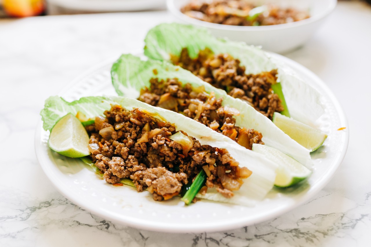 Ground Beef Lettuce Wraps on a plate with lime edges. These lettuce wraps are using romaine lettuce. 
