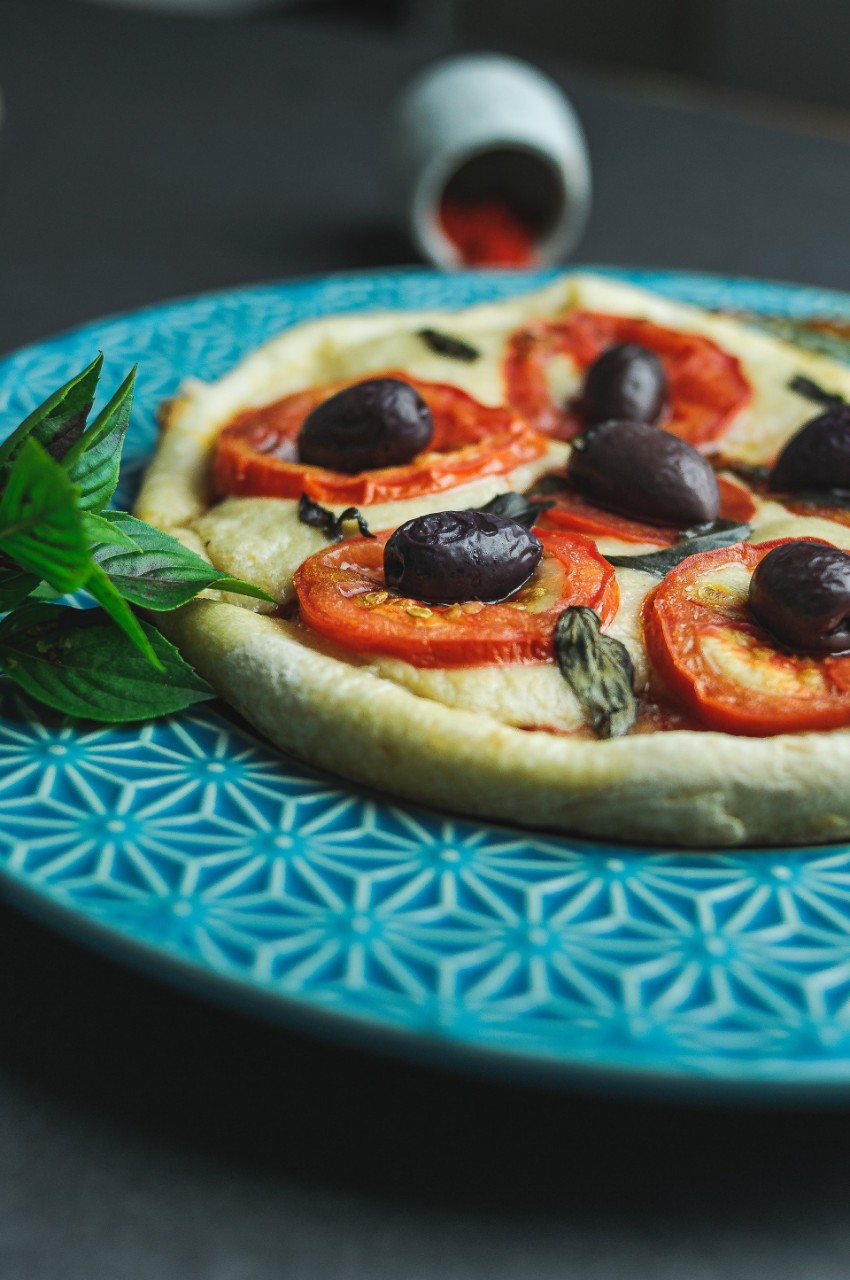 Une pizza avec des olives noires