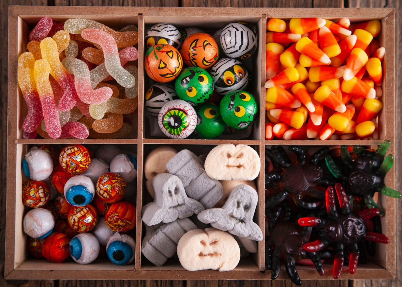 Halloween variety of sweets in a wooden box on a vintage wooden table