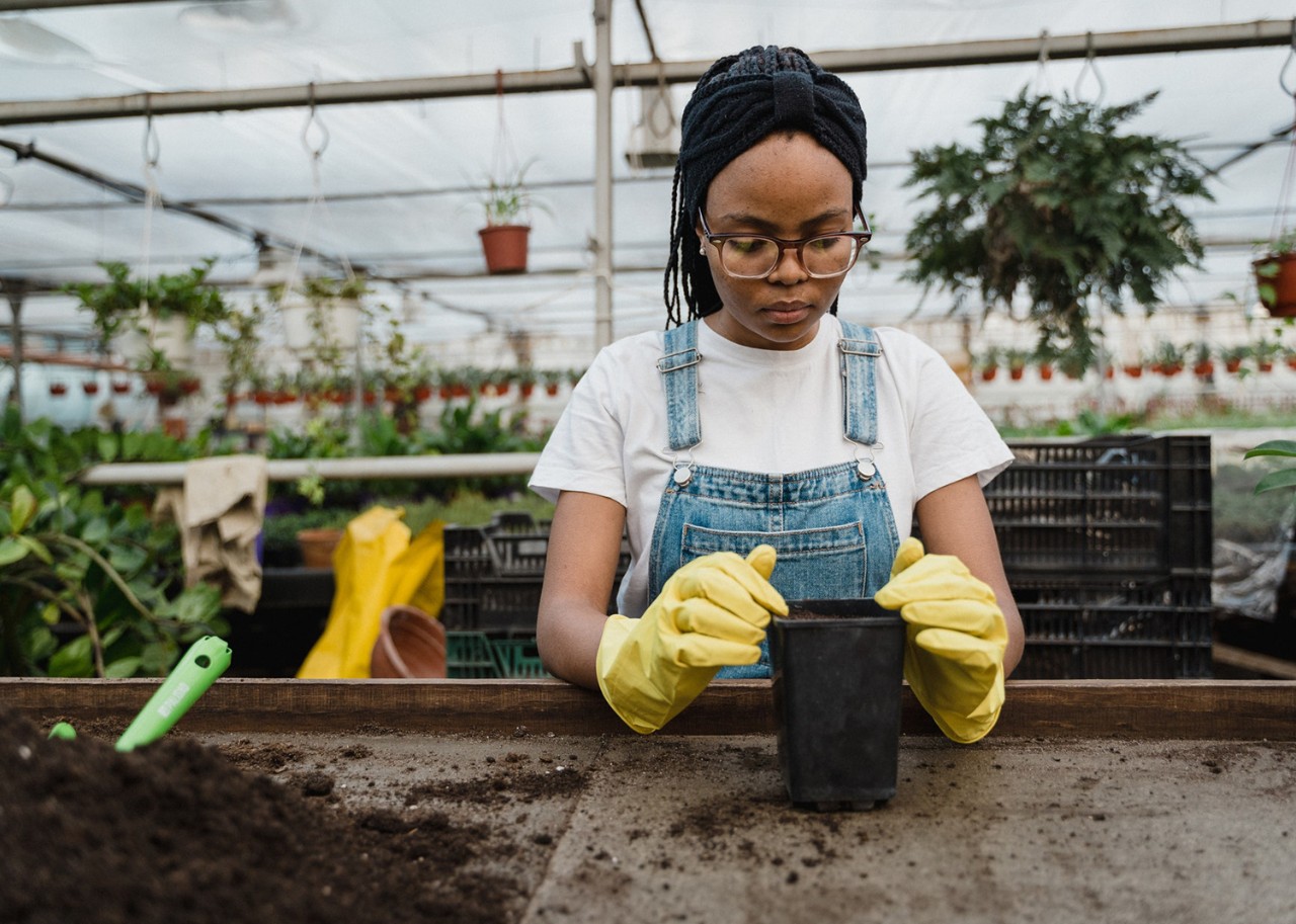Une femme noire jardine et s'occupe du compost