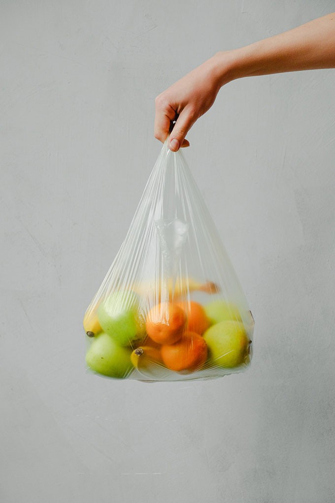 Une personne tient un sac de fruits. Pour réduire ses déchets, il est important de trier