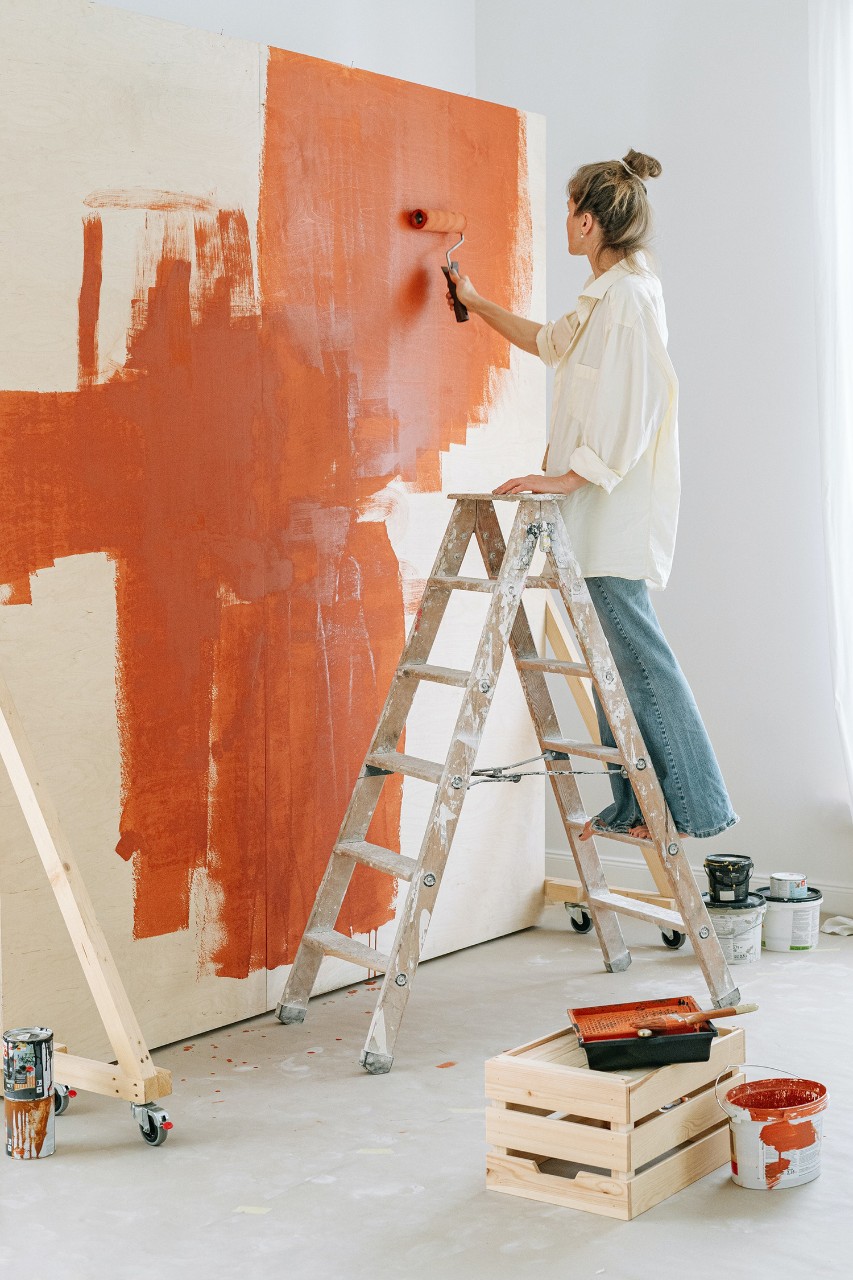 Une femme peint un mur