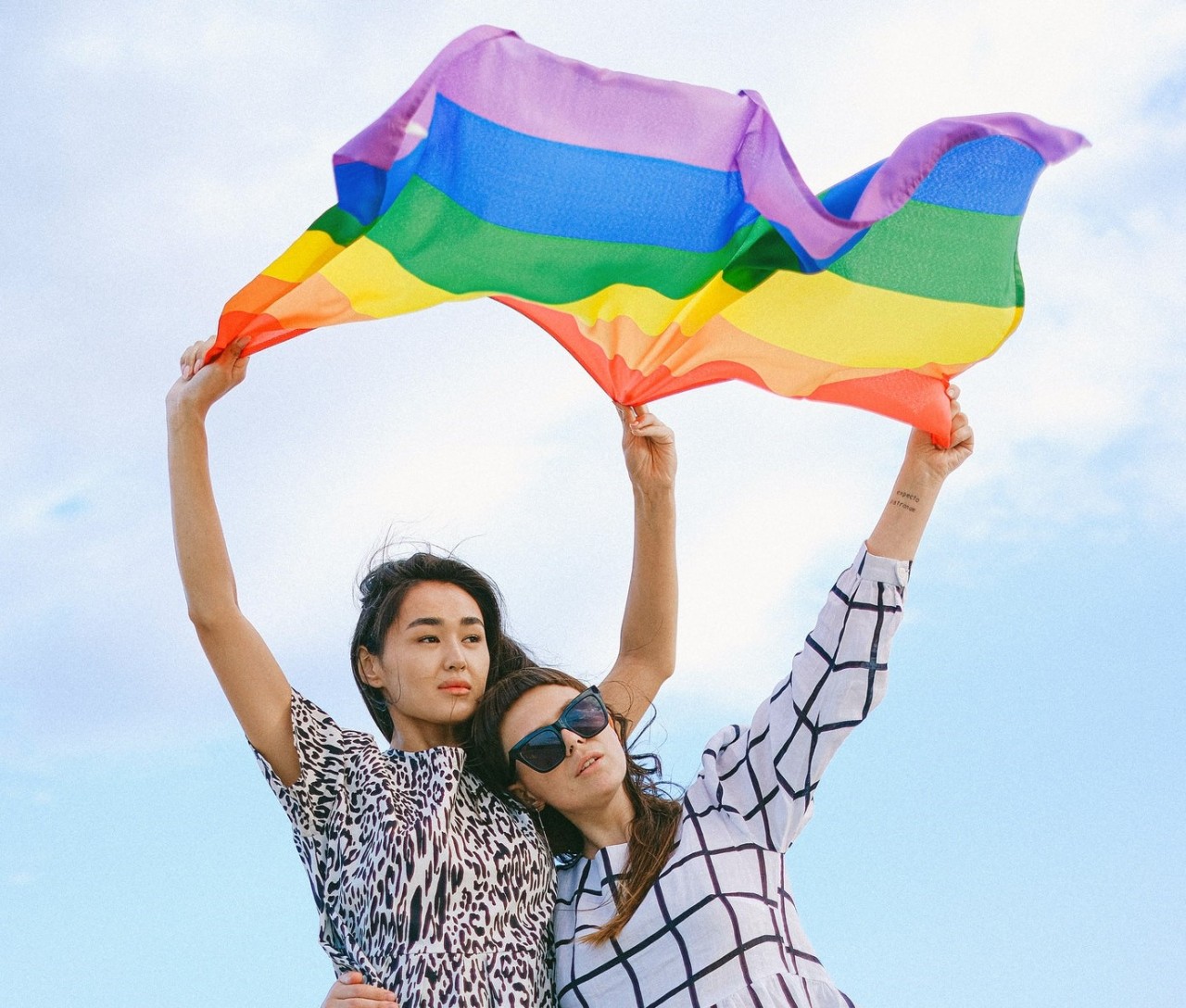 Deux femmes tiennent un drapeau LGBTQ+