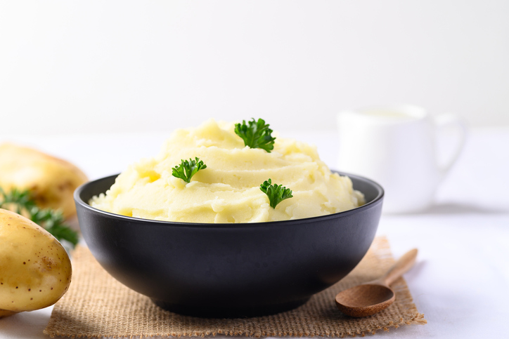 Mashed potato with parsley in black bowl, Homemade food