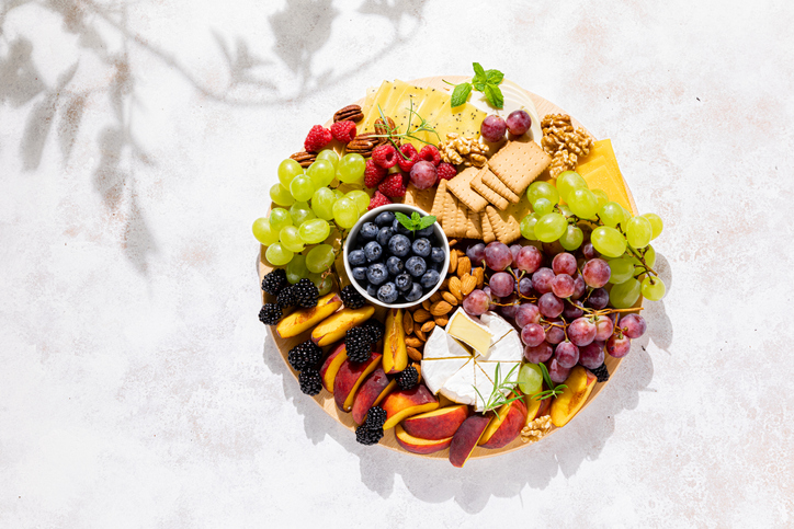 Autumn cheese board with fresh fruits and berries served with white wine, top view