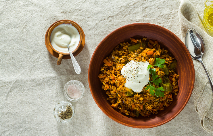 rice with vegetables and yogurt. in earthenware on a linen tablecloth