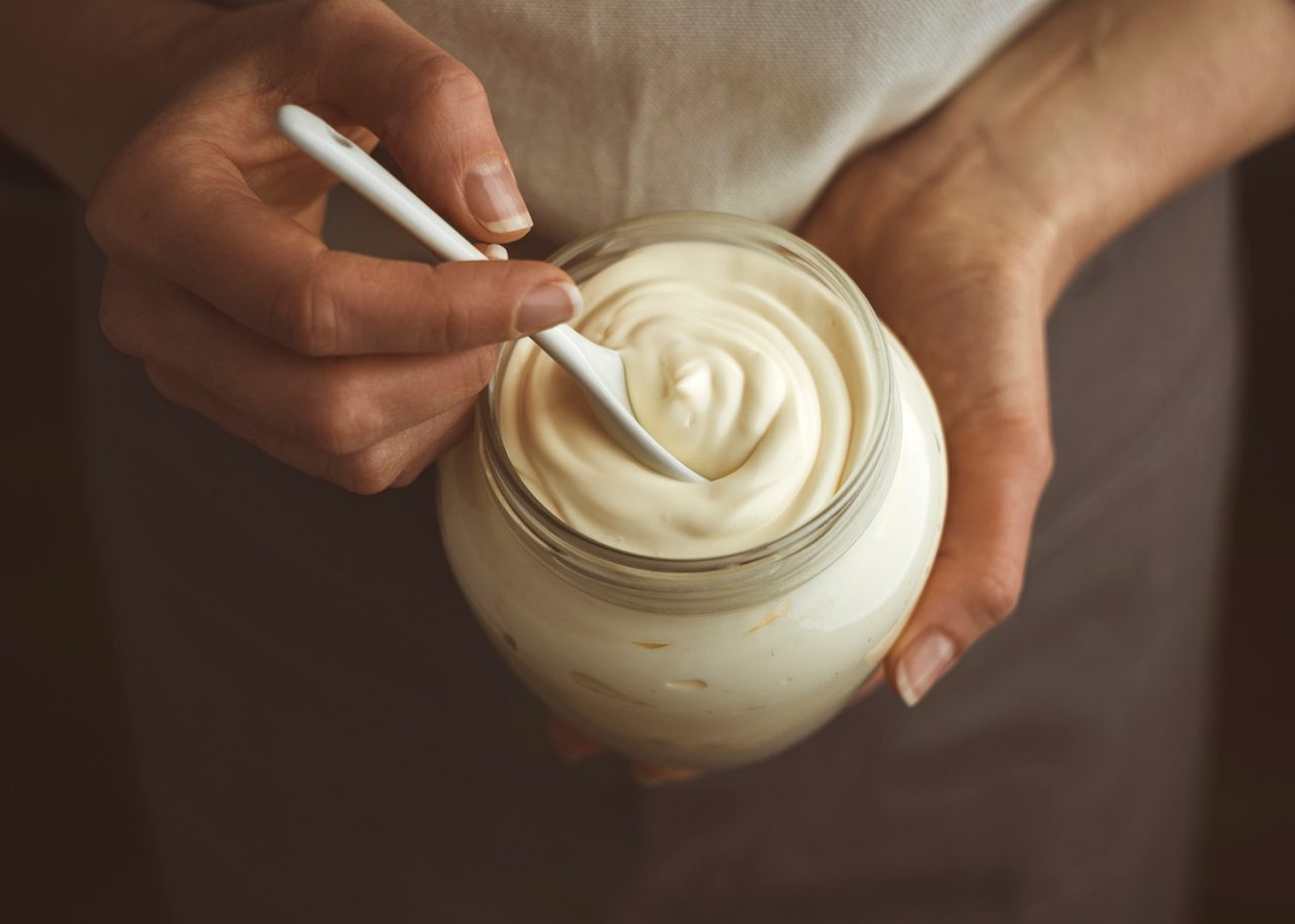 Glass jar of mayonnaise with a spoon.