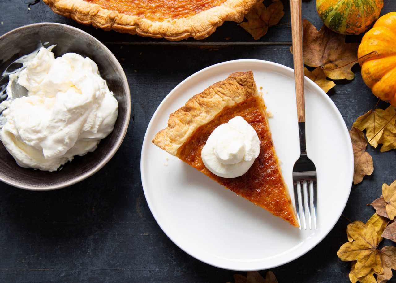 Portion of pumpkin pie with whipped cream, a traditional thanksgiving dessert. Top view
