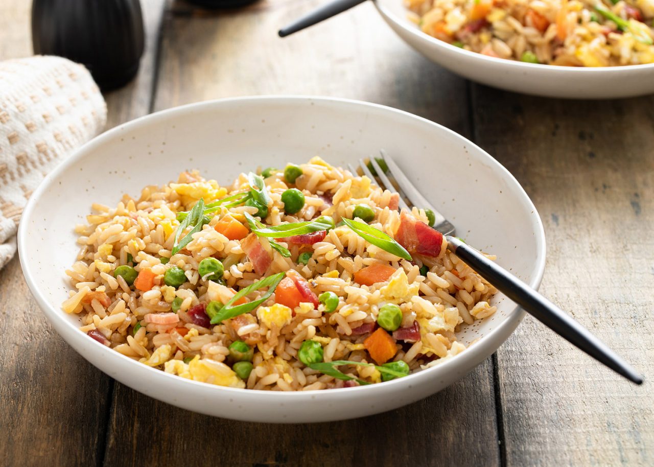 Breakfast fried rice with bacon, carrots, peas, green onions and scrambled eggs