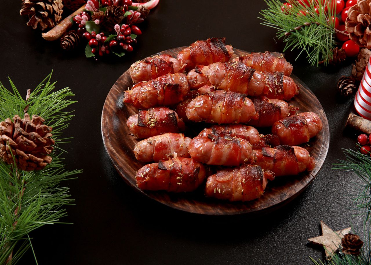 In the United Kingdom, "Pigs in Blankets" refers to small sausages (usually chipolatas) wrapped in bacon. They are a traditional accompaniment to roast turkey in a Christmas dinner. Marinated with a savoury sauce, also used at Parties and Events as buffet snack with cocktail sticks