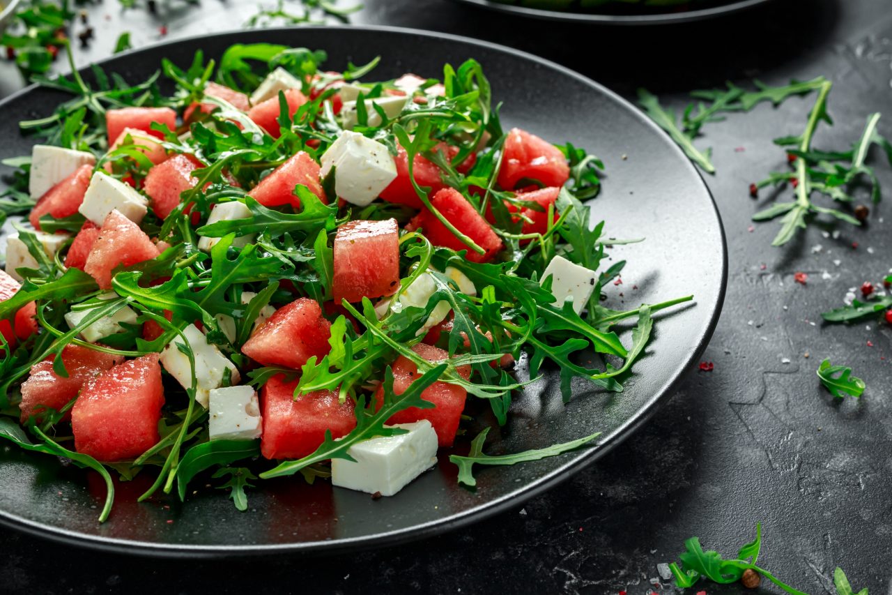 Fresh Juicy Watermelon arugula Feta salad with mint and orange, lemon dressing. summer dish. healthy food.