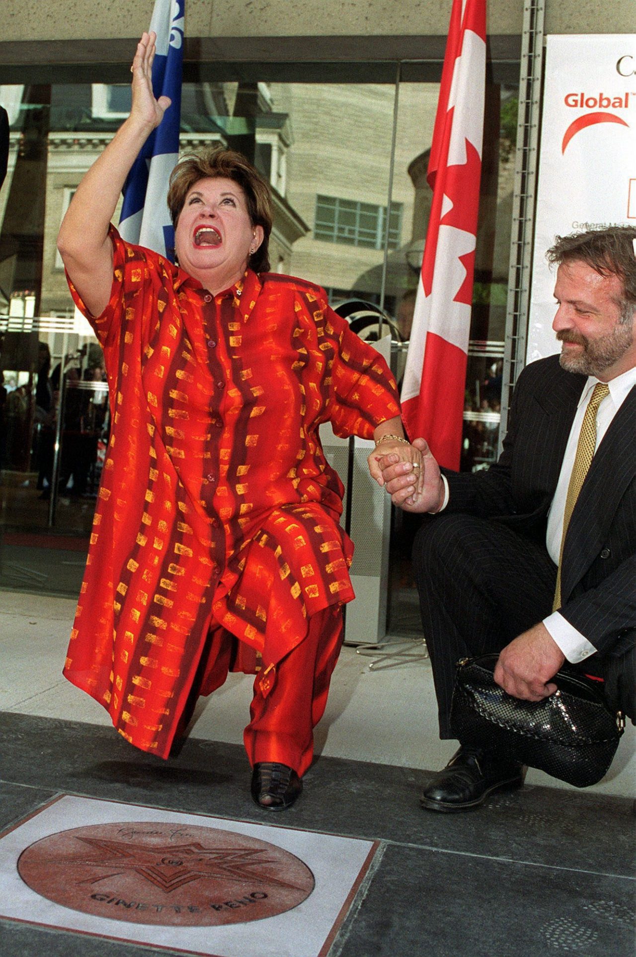 Ginette Reno receives her star on Canada's Walk of Fame Friday, June 23, 2000. Man at right is unidentified. (CP PHOTO/Tannis Toohey)