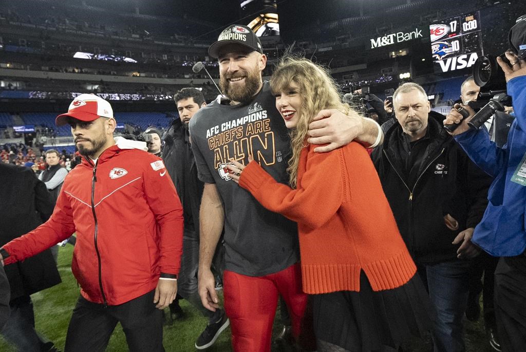 FILE - Kansas City Chiefs tight end Travis Kelce and Taylor Swift walk together after an AFC Championship NFL football game between the Chiefs and the Baltimore Ravens, Jan. 28, 2024, in Baltimore. For weeks, scrutiny over Swift’s travel has been bubbling up on social media, with people pointing out the planet-warming emissions of carbon dioxide released with every flight. (AP Photo/Julio Cortez, File)