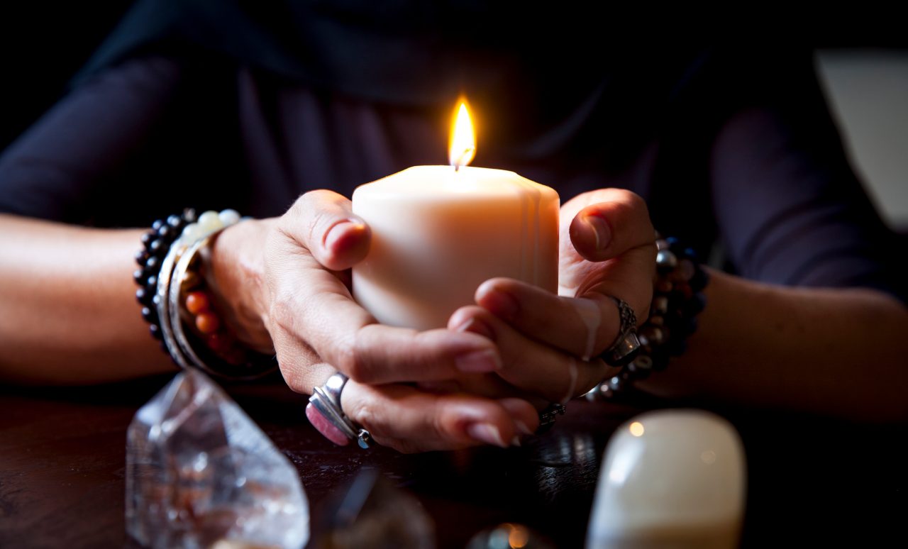 female hands holding a burning candle