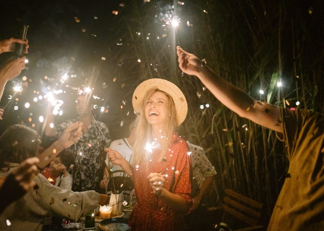 Photo of a young woman celebrating and having a summer dinner party with her family and friends.