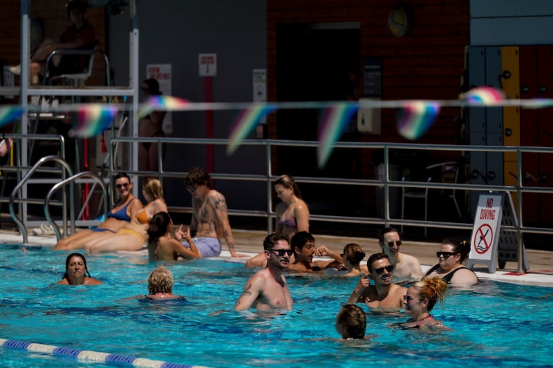 Des gens se baignent dans une piscine extérieure à Londres, le mardi 23 juin 2026, alors qu’une vague de chaleur est prévue dans toute la Grande-Bretagne.