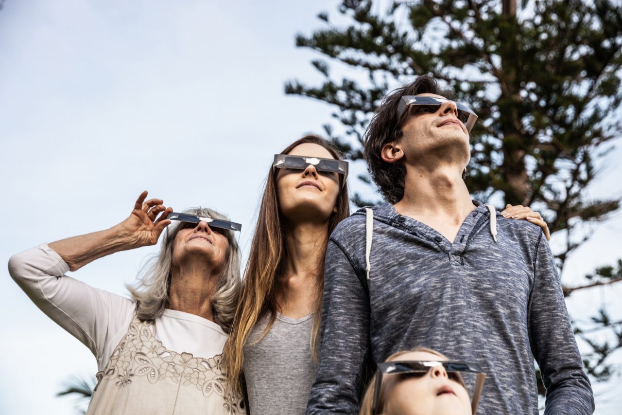 Family looking at Solar Eclipse using solar glasses.