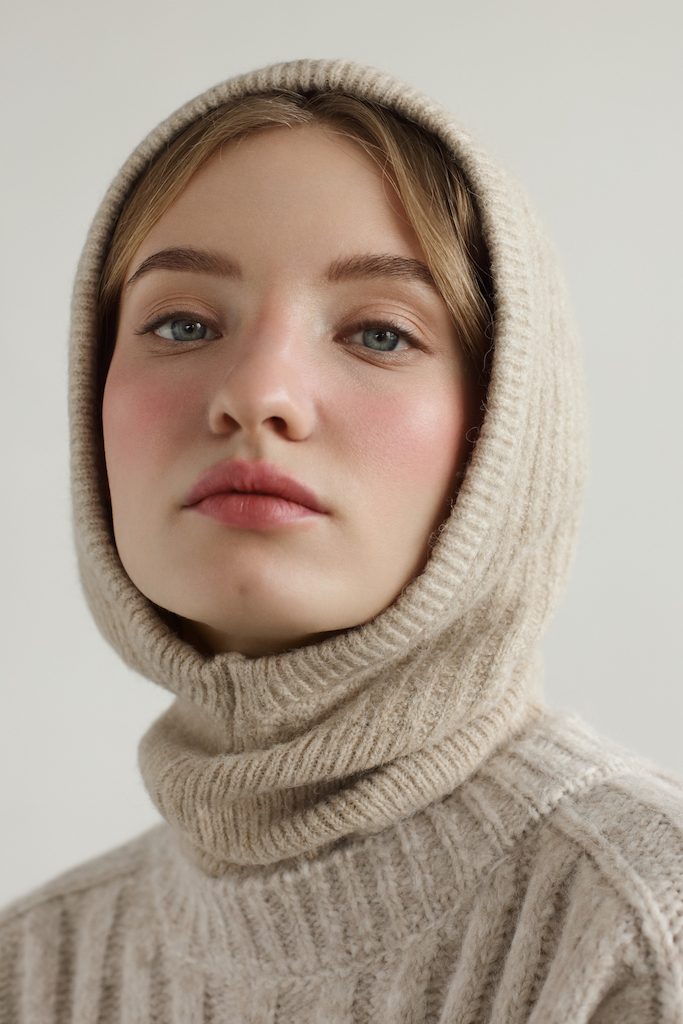 Portrait of young beautiful woman wearing beige knitted hood and sweater