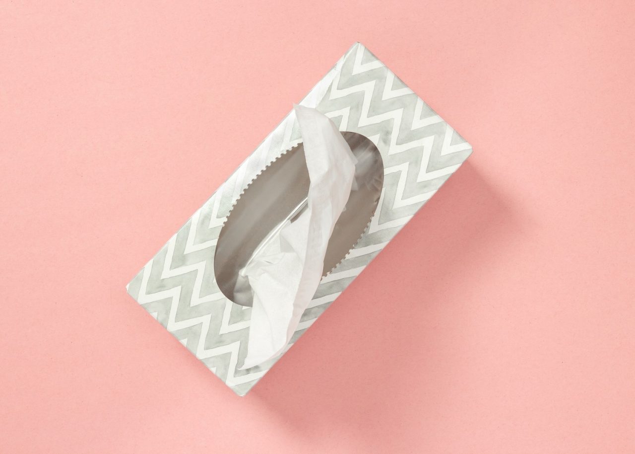 Gray tissue box on pastel pink background. Healthcare and hygiene.