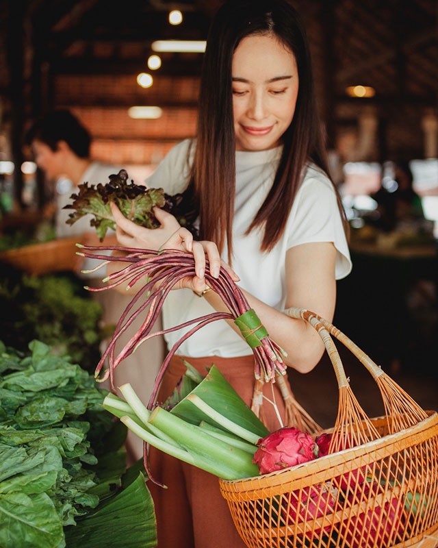 Une femme achète ses légumes locaux au marché