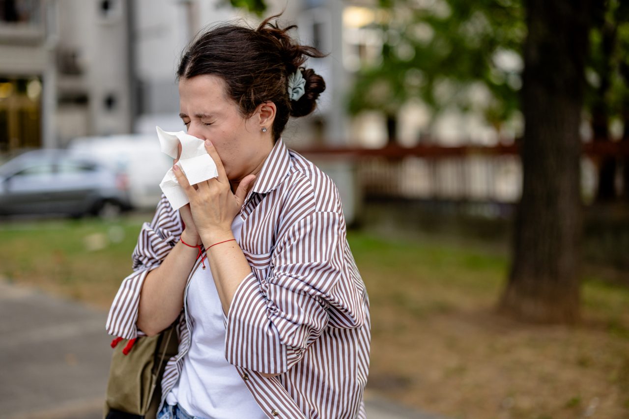 The young woman's day out becomes an interrupted affair as she can't stop sneezing and reaching for tissues, signalling allergy issues