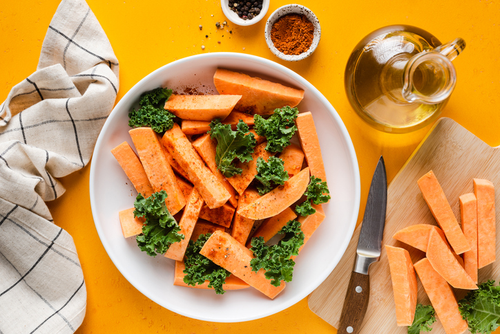 Baking sweet potato wedges and kale cabbage. Healthy vegan vegetable meal preparation recipe