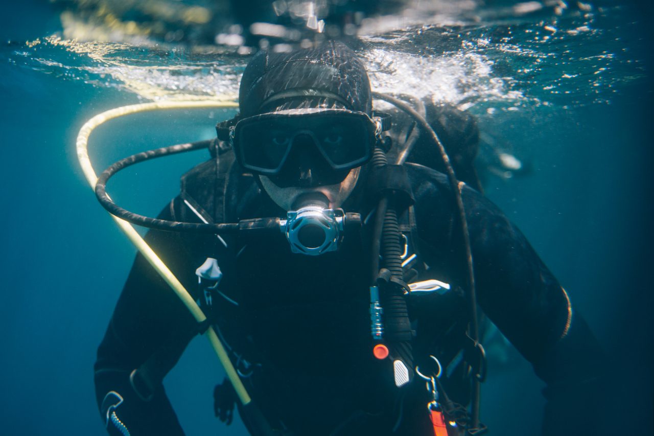 Scuba diver underwater looking at camera.